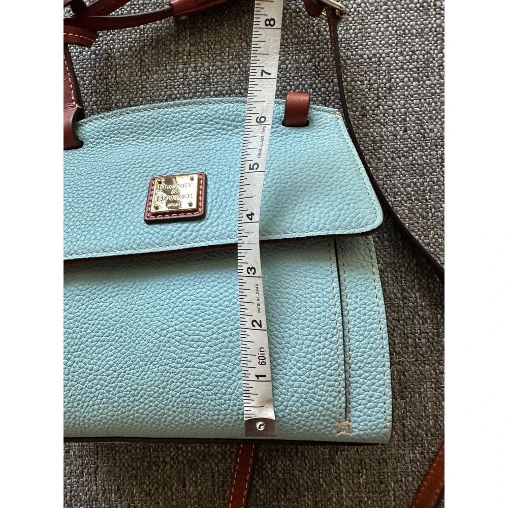 This is a Dooney & Bourke Pebble Grain East/West Flap Crossbody in a light blue